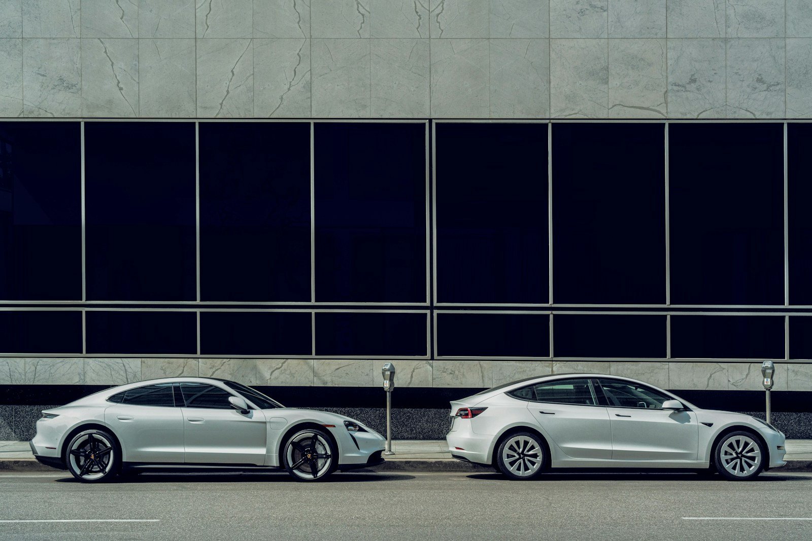 white sedan parked beside white and black building